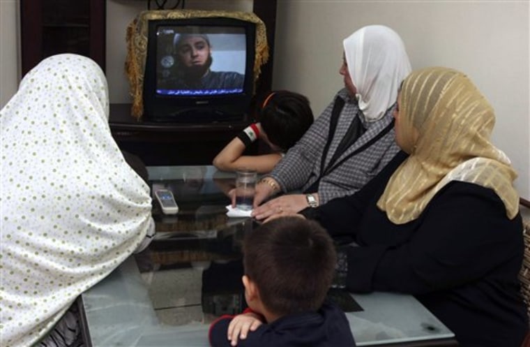 In this photo taken Saturday, Sept. 4, 2010, a Syrian family watches the Syrian series titled \"Ma Malakat Aymanukum,\" Arabic for \"what your right hand possesses,\" in Damascus, Syria. In a new Syrian soap opera, a beautiful green-eyed young woman named Layla is torn over whether to take off the niqab, the billowing black Islamic garb that hides every part of her except her eyes. The 30-episode drama, aired on state TV during the Islamic holy month of Ramadan, has sparked intense debate in this Arab nation of 22 million, which is ruled by a secular, authoritarian regime that has clamped down on Islamic extremism in the past. (AP Photo/Bassem Tellawi)